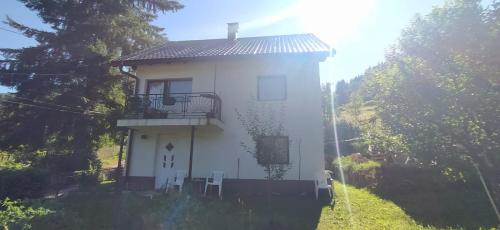 a small white house with a balcony on a hill at Vareš in Vareš