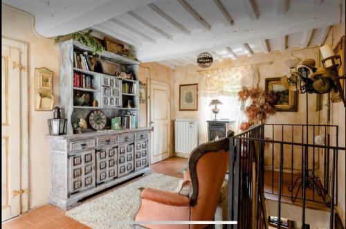 a living room with a fireplace and a chair at Il Priorato in Pescia