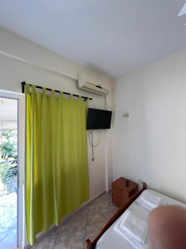 a room with a green curtain and a bed at Dhoma Plazhi Husi in Borsh