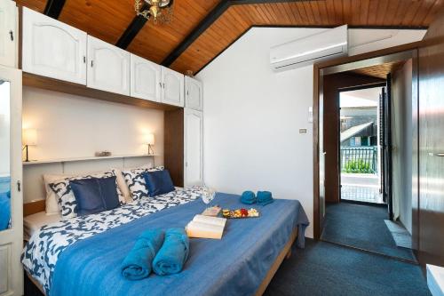 a bedroom with a large bed with blue pillows at House Brunac with parking in Vodice