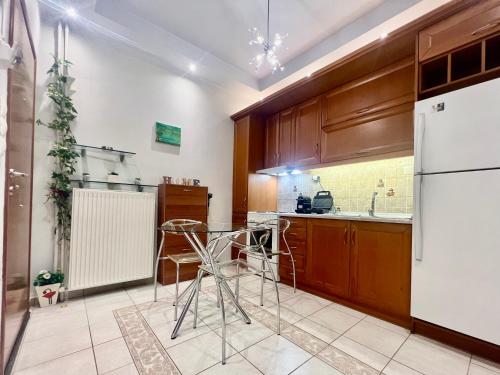 a kitchen with a white refrigerator and wooden cabinets at Elegant Downtown Retreat in Kalamata