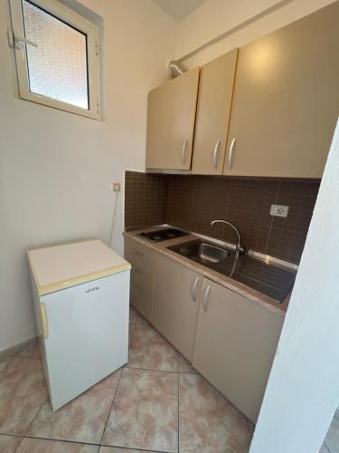 a small kitchen with a sink and a refrigerator at Dhoma Plazhi Husi in Himare