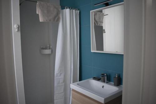 a bathroom with a white shower curtain and a sink at Placeta Boutique in Rute