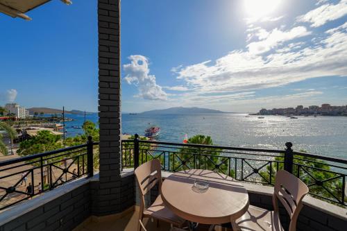 a balcony with a table and chairs and a view of the water at Hotel Summer in Sarandë