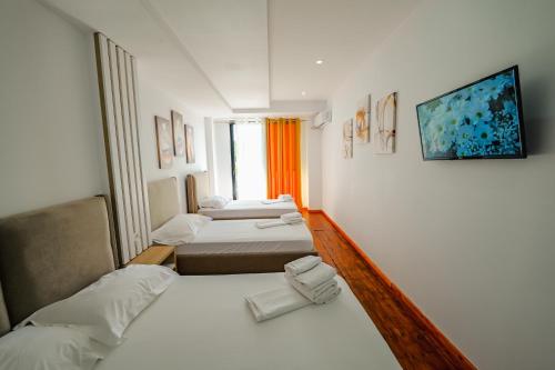 een hotelkamer met 2 bedden en een raam bij Hotel Summer in Sarandë