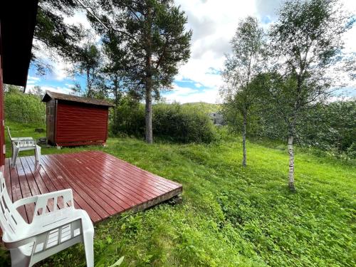 a wooden deck with a bench and a smallshed at Ådnebu by Norgesbooking - cabin with 3 bedrooms in Geilo