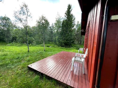 eine Holzterrasse mit einem weißen Stuhl auf einem Haus in der Unterkunft Ådnebu by Norgesbooking - cabin with 3 bedrooms in Geilo