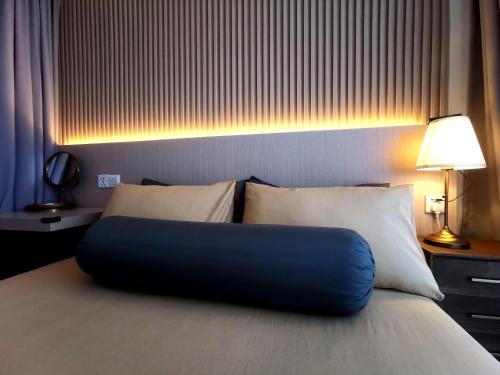 - un lit avec un oreiller bleu dans l'établissement The Shore Artsy Studio Kota Kinabalu, à Kota Kinabalu