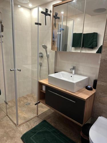 uma casa de banho com um lavatório e um chuveiro em Appartement Anna em Niederau