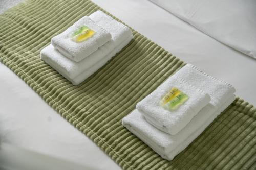 2 toallas encima de la cama en Spacious 3 BR house wParking & Garden, Wimbledon, en New Malden