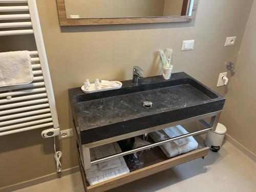 a bathroom sink with a black marble counter top at Le dimore di Bobo in Bernalda