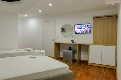 a bedroom with a bed and a tv on a wall at Hotel Summer in Sarandë