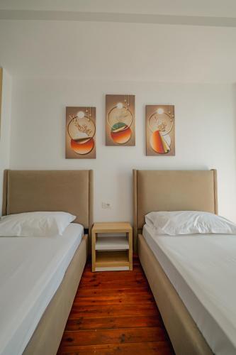 two beds sitting next to each other in a room at Hotel Summer in Sarandë