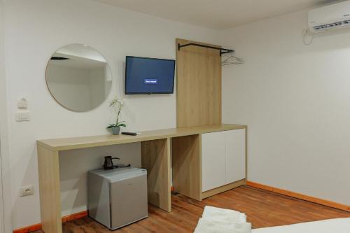 a room with a desk with a tv and a mirror at Hotel Summer in Sarandë