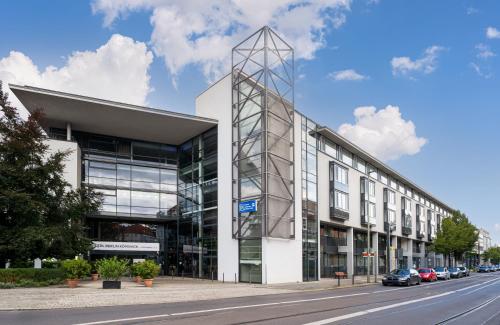 an office building with a glass facade on a street at NYX Hotel Berlin Köpenick by Leonardo Hotels in Berlin
