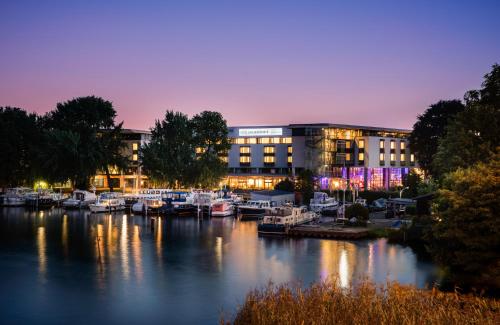 a marina in front of a building with boats in the water at HOTEL BERLIN KÖPENICK by Leonardo Hotels in Berlin