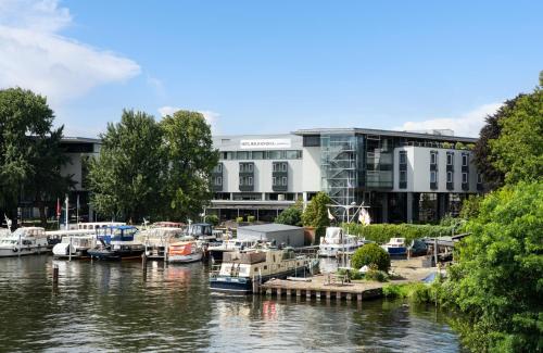 einen Yachthafen mit vor einem Gebäude angedockten Booten in der Unterkunft HOTEL BERLIN KÖPENICK by Leonardo Hotels in Berlin