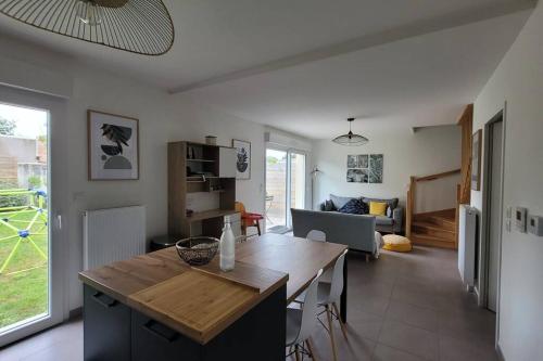 une cuisine et un salon avec une table et un canapé dans l'établissement Maison avec jardin sur Berck, à Berck-sur-Mer
