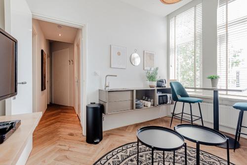 a living room with two chairs and a kitchen at Studio Estelle's with Private Parking in Zandvoort