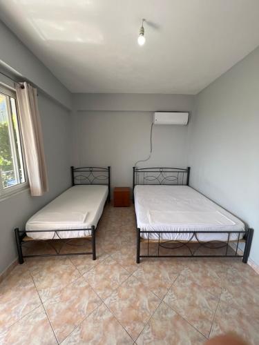 two beds sitting in a room with a window at Dhoma Plazhi Husi in Borsh
