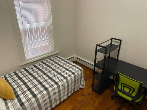 a bedroom with a bed and a desk next to a window at Frog Hollow Red Door Haven in Hartford