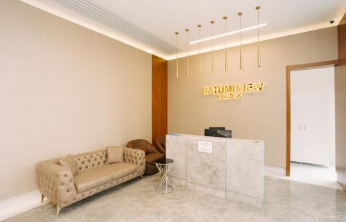 a waiting room with a couch and a table at Marina Batumi Sea View in Batumi