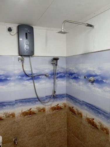 a bathroom with a shower with fish on the wall at 152-Abhaya Place Homestay in Talalla