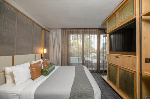 a bedroom with a bed and a flat screen tv at The Social House Nairobi, a Preferred Lifestyle Hotel in Nairobi
