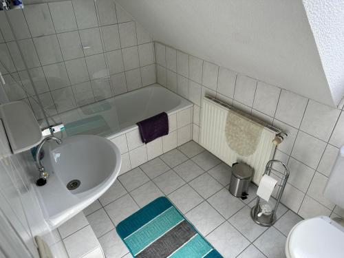 ein Badezimmer mit einem Waschbecken, einer Badewanne und einem WC in der Unterkunft Zentrale Doppelbettzimmer in Nordenham