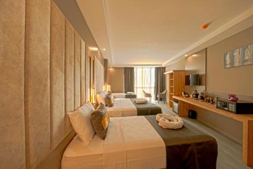 ein Hotelzimmer mit 3 Betten in einem Zimmer in der Unterkunft İstanbul City Airport Hotel in Istanbul
