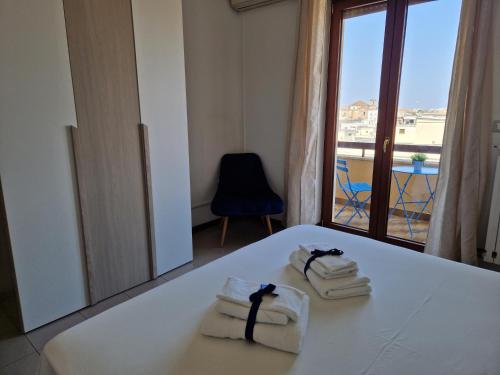 een kamer met handdoeken op een tafel met een raam bij Casa Rosetta in Lecce