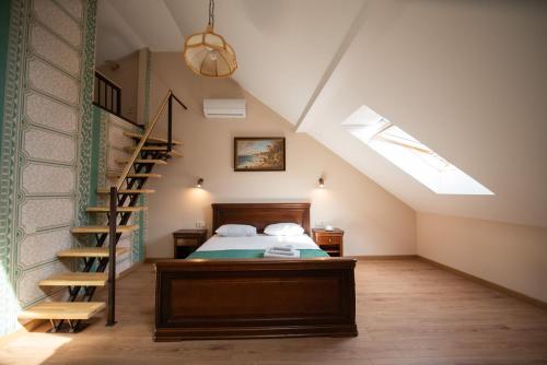 a attic bedroom with a bed and a staircase at Apart Yaroslava Osmomysla 9 Square - city center in Lviv