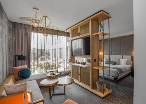 a hotel room with a bed and a couch and a tv at The Social House Nairobi, a Preferred Lifestyle Hotel in Nairobi