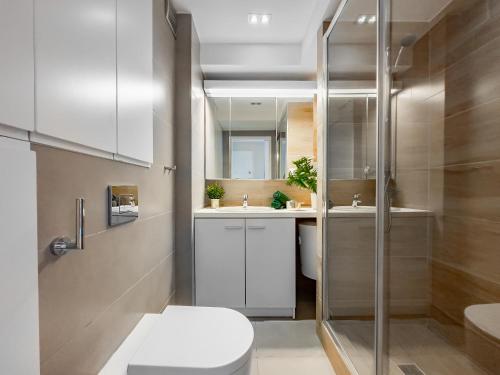 a bathroom with a shower and a toilet and a sink at Apartament z widokiem na panoramę miasta in Kraków