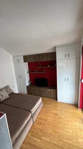 uma sala de estar com uma cama e um quarto com armários em Apartman MIA em Ohrid