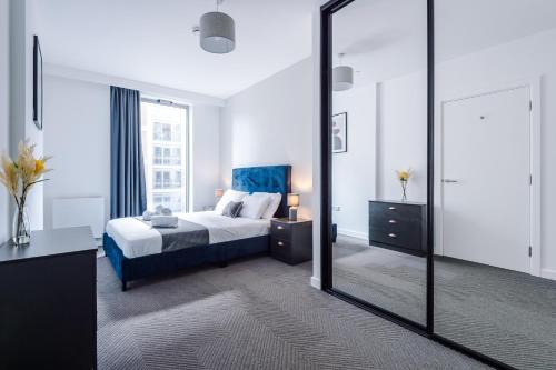 Un dormitorio con una cama y un espejo grande. en Hilltop Serviced Apartments - Ancoats, en Mánchester