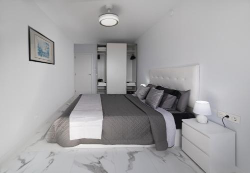 Habitación blanca con cama grande y suelo de mármol blanco. en Club Paraiso 1306 en Playa Paraiso