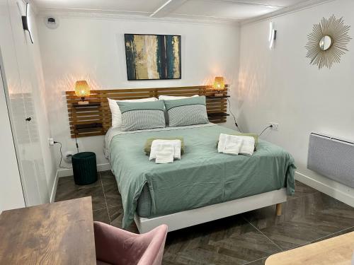 ein Schlafzimmer mit einem Bett mit zwei Handtüchern darauf in der Unterkunft Logement GUÉNOT pour 5 personnes sur Paris 11 in Paris