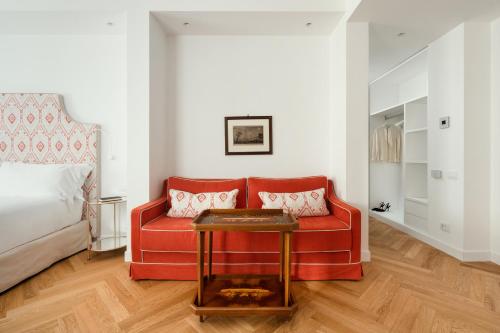 a living room with a red couch and a bed at Hotel Morfeo in Milan