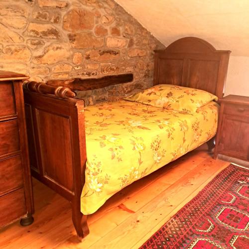 a bedroom with a bed and a stone wall at Holiday house Luin in Komen