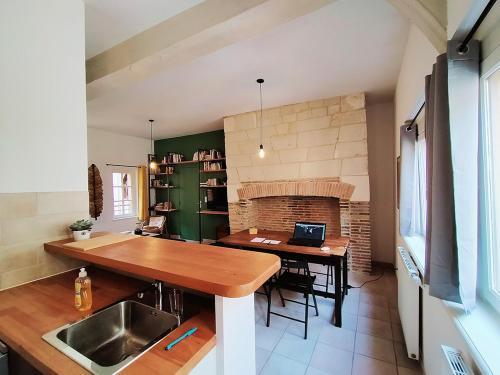 une cuisine avec une table en bois et une cheminée dans l'établissement Chez CATY, à Troyes