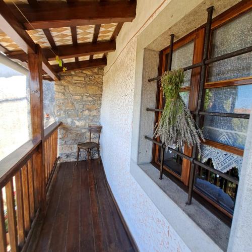 a wooden porch with a bench and a window at Holiday house Luin in Komen