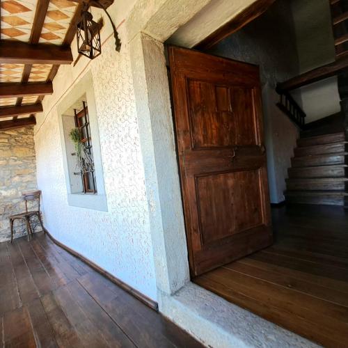 an empty room with a wooden door and stairs at Holiday house Luin in Komen