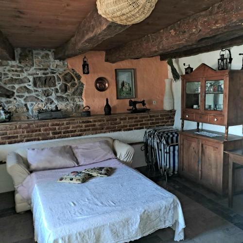 Komen的住宿－Holiday house Luin，一间卧室设有一张床和石墙