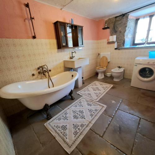 a bathroom with a tub and a sink and a toilet at Holiday house Luin in Komen