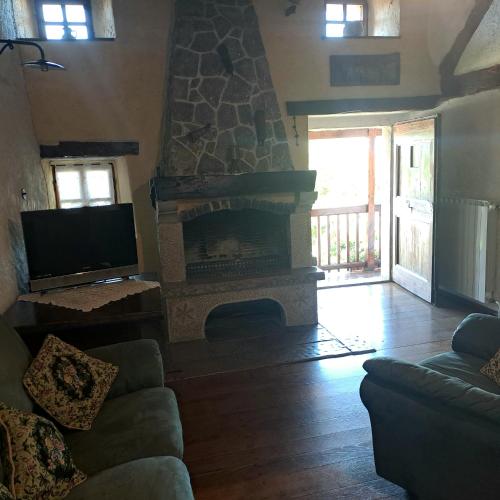a living room with a stone fireplace and a couch at Holiday house Luin in Komen
