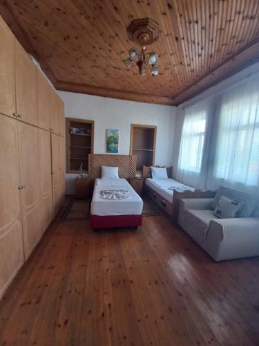 a large room with two beds and a couch at MiziriGuestHouse in Gjirokastër