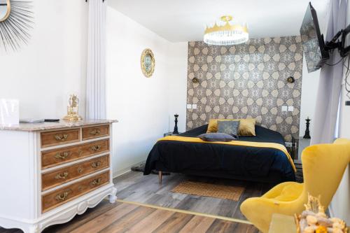 a bedroom with a bed and a dresser at Appartement de la noblesse - designed by C.M in Sélestat