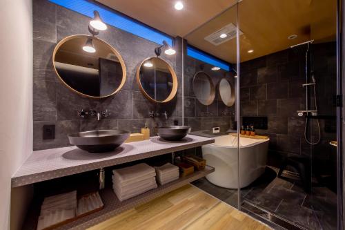 ein Badezimmer mit zwei Waschbecken und zwei Spiegeln in der Unterkunft 【Oyado街】宿泊者限定！貸切クルーザー・SUPツアー　別荘感覚で新築一軒家貸切ハウステンボス近く in Hayaki