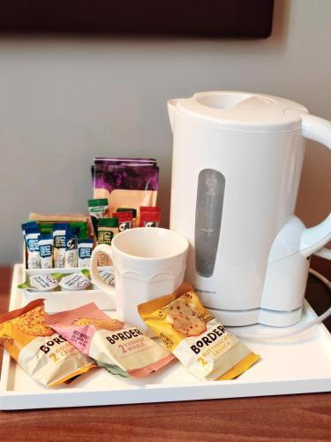 a plate with food and a mug and a coffee maker at Frederick House Hotel in Edinburgh